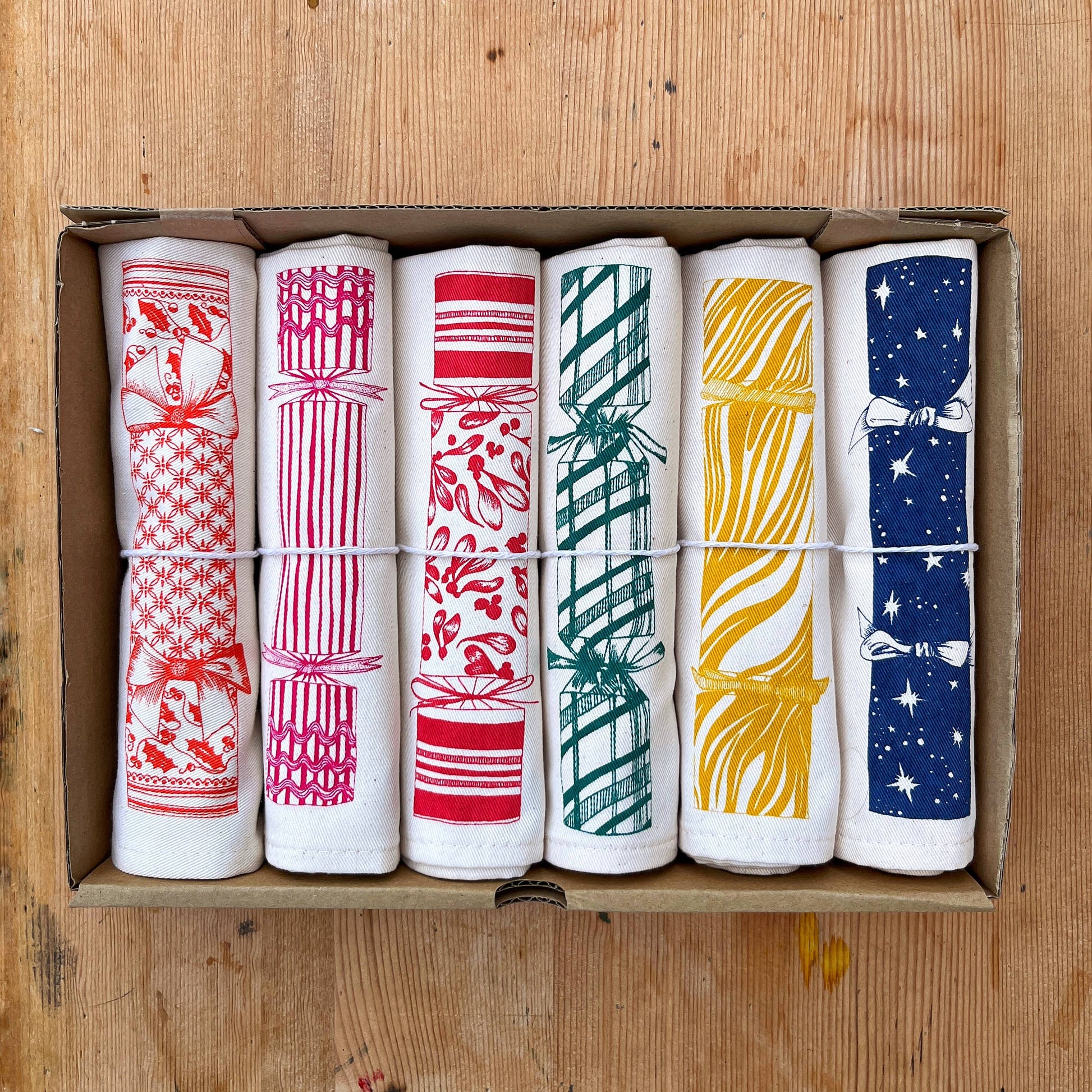 Set of 6 100% cotton Christmas Cracker Napkins by Lottie Day, featuring printed cracker prizes